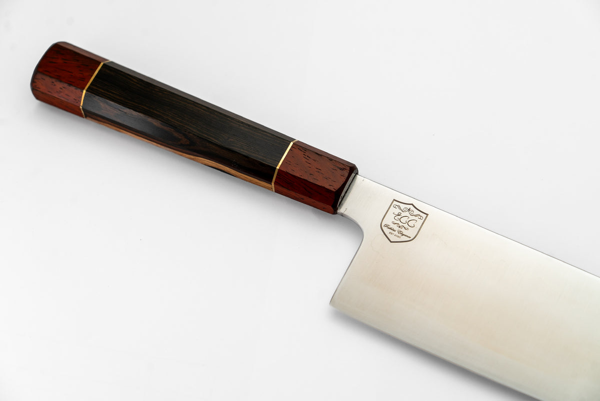 Close-up of the Santoku Knife's dark faceted handle, reddish-brown endcaps and gold-colored bands